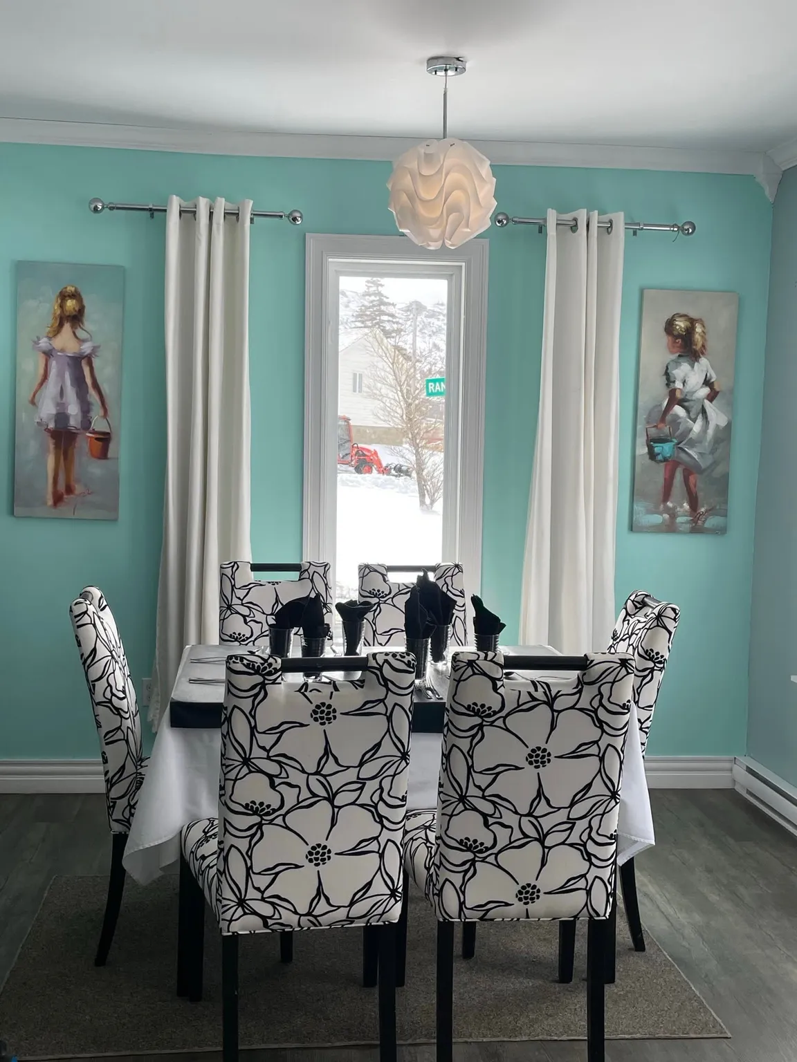 Pier 39 dining room with turquoise walls, patterned chairs and a table set for dinner